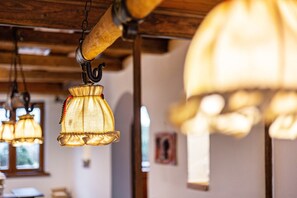 A series of hanging lamps with a rustic design, wooden beams, and a framed picture on the wall.