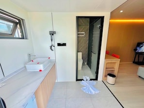 Junior suite, uitzicht op strand | Badkamer | Gratis toiletartikelen, een haardroger, handdoeken, zeep