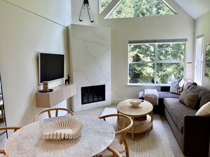 A modern living room with a fireplace, a television, and a sofa. - Whistler Serenity Sanctuary (Whistler)