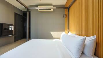 Een moderne hotelkamer met een groot bed, een ingebouwde televisie en een wand van hout.