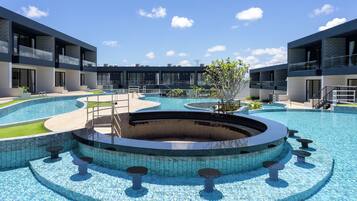 A modern pool area with a circular design, surrounded by multi-story buildings with balconies.