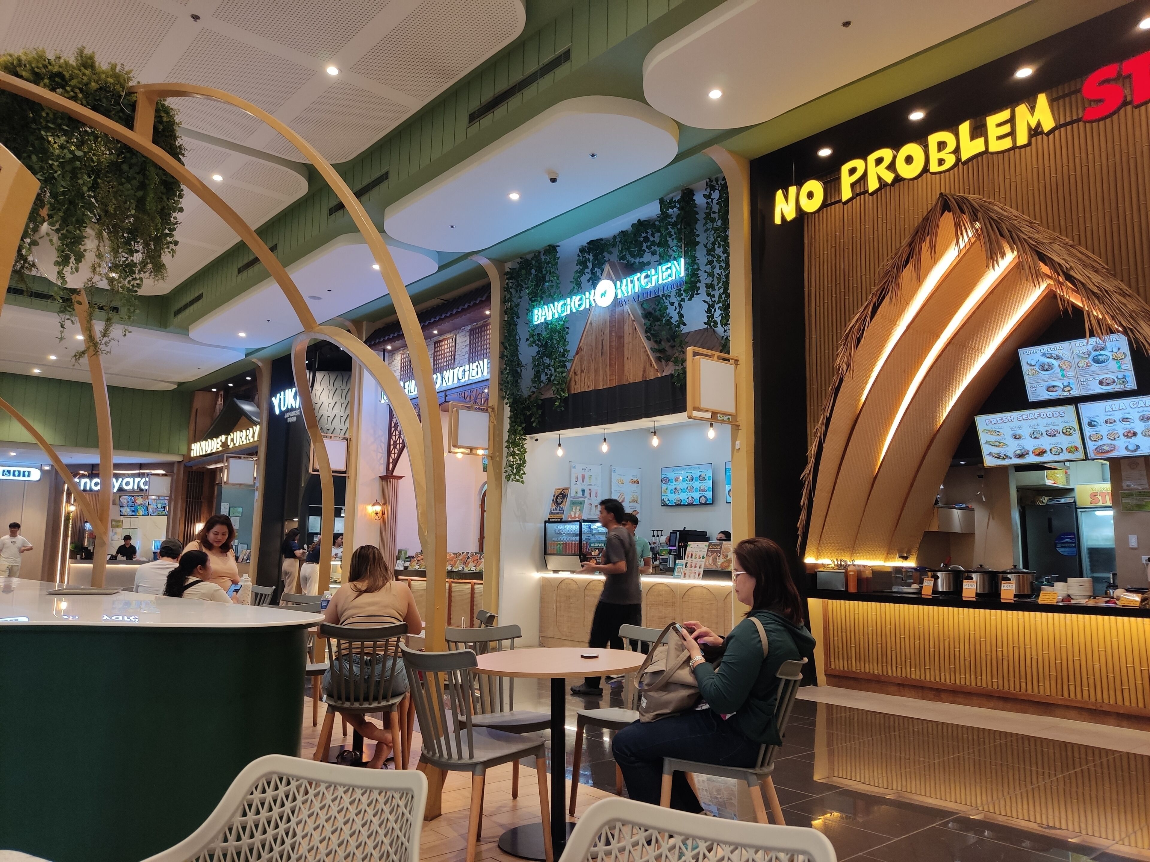 An indoor dining area with multiple seating arrangements and a counter with a menu display.