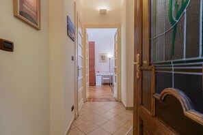A hallway with a wooden door, a small desk, and a framed picture on the wall. - Galliari Comfort Home by Wonderful Italy (Turin)
