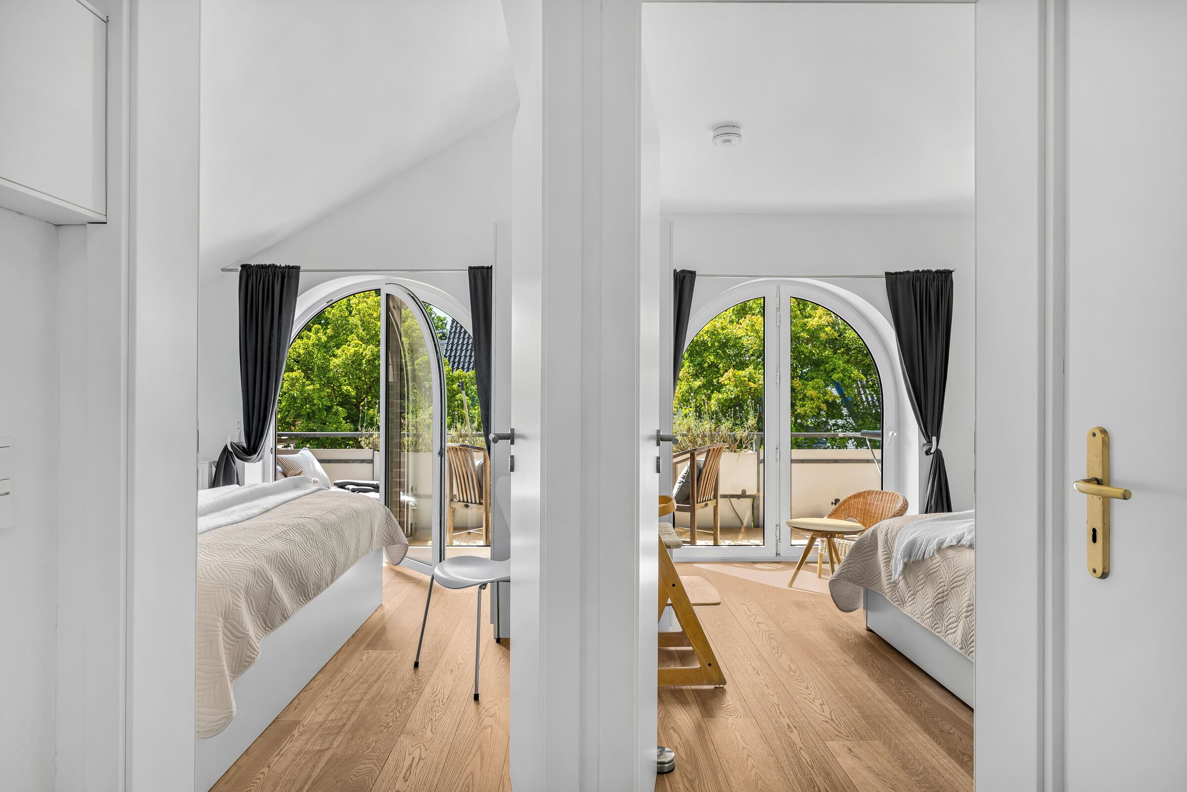 Ein modernes Schlafzimmer mit großem Fenster, einem Bett und Holzboden.