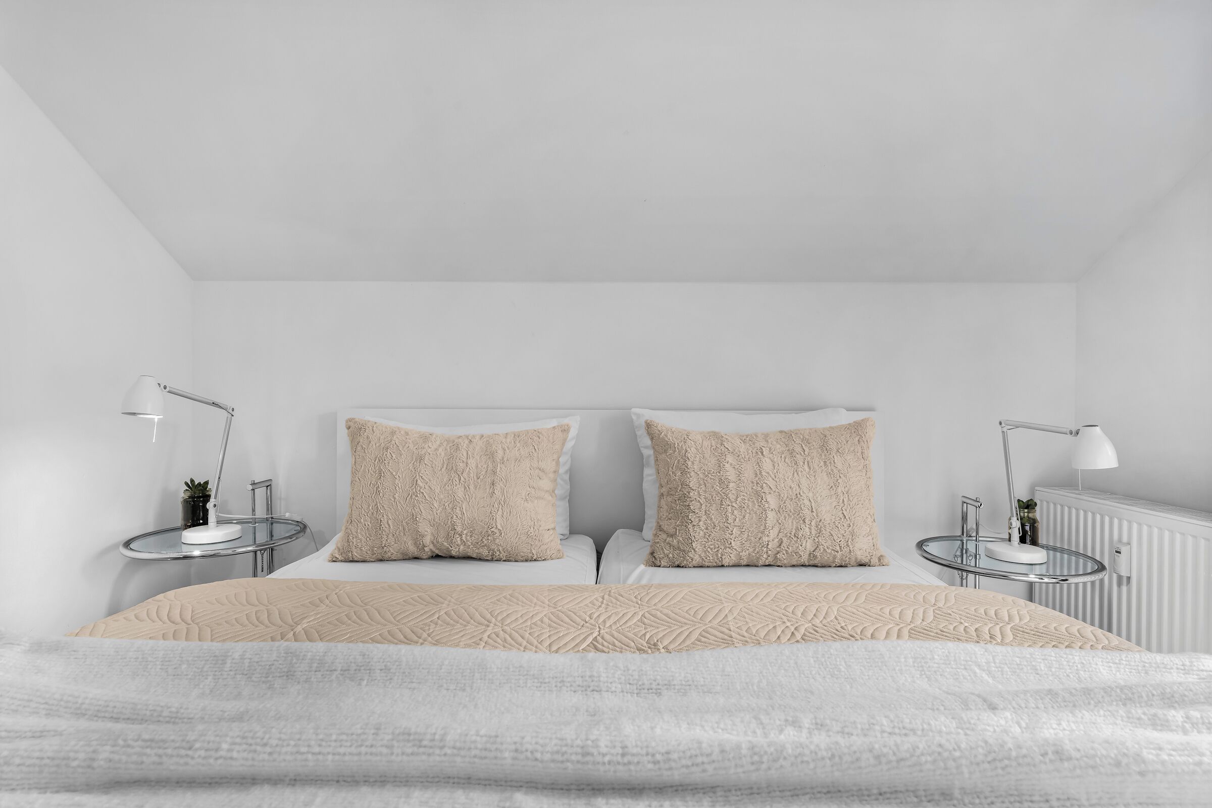 Ein schlichter Schlafzimmer mit einem Bett, zwei Nachttischen und zwei Lampen.