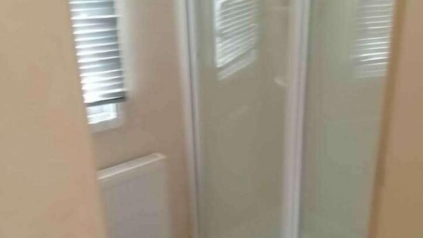 Ein schmaler Flur mit einer Glastür zu einem Zimmer.