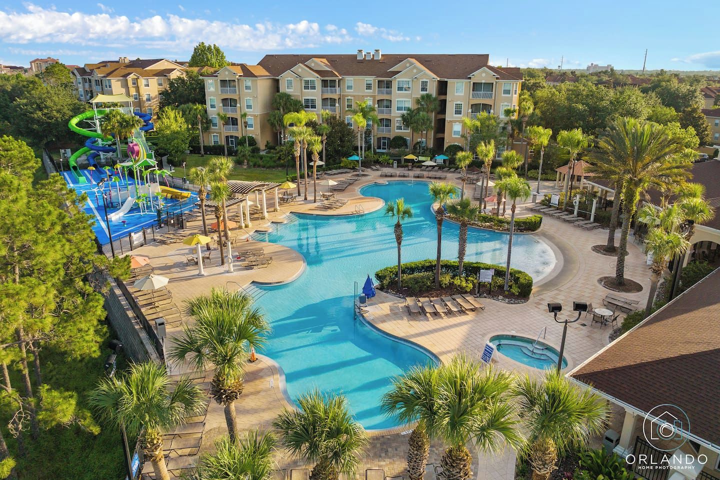Un resort con una piscina grande, palmeras y un parque acuático.