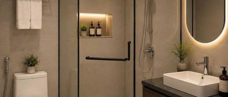A modern bathroom with a glass-enclosed shower, a toilet, a sink, and a mirror.