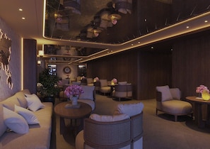 A modern lounge area with sofas, armchairs, and round tables, featuring ambient lighting and decorative elements. - Minerva Prestige Hotel (Hanoi)
