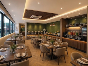A restaurant with multiple dining tables, a bar area with a wine and cocktail selection, and a view through large windows. - Minerva Prestige Hotel (Hanoi)