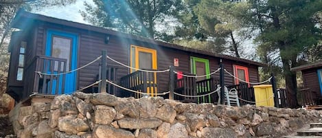 A row of cabins with a stone wall in the foreground.