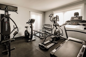 A gym with various exercise equipment, including treadmills, a stationary bike, and weight machines. - Cozy 1-bedroom hotel with AC in gorgeous San Ġiljan (San Ġiljan)