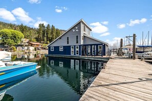 A docked boat, a wooden pier, and a building with a gabled roof.