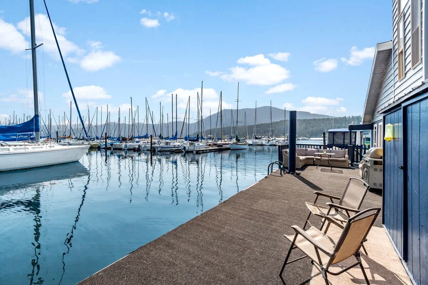 A marina with boats docked, a covered seating area, and a building with a blue exterior.