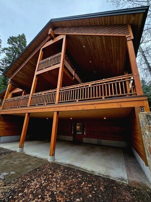 A two-story wooden cabin with a balcony on the upper level. - Stylish Mountain Retreat with Game Room & Private Fire Pit in McCall, Idaho (McCall)