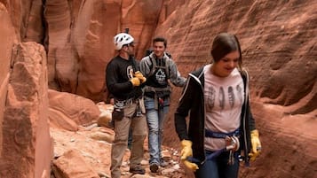 Un canyon étroit aux parois rocheuses, où un groupe de personnes fait de la randonnée.