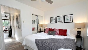 A bedroom with a bed, bedside lamps, a mirror, and artwork on the wall. - Chic Weekend Getaway Perfect for Visiting the Grand Canyon in Utah (Orderville)