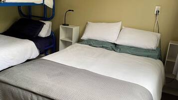 A hotel room with a bed, a desk, and a chair.