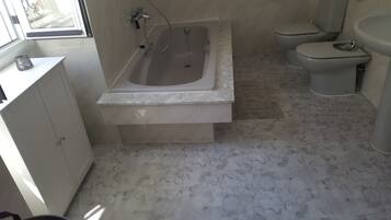 Een bidet, handdoeken, zeep, toiletpapier
