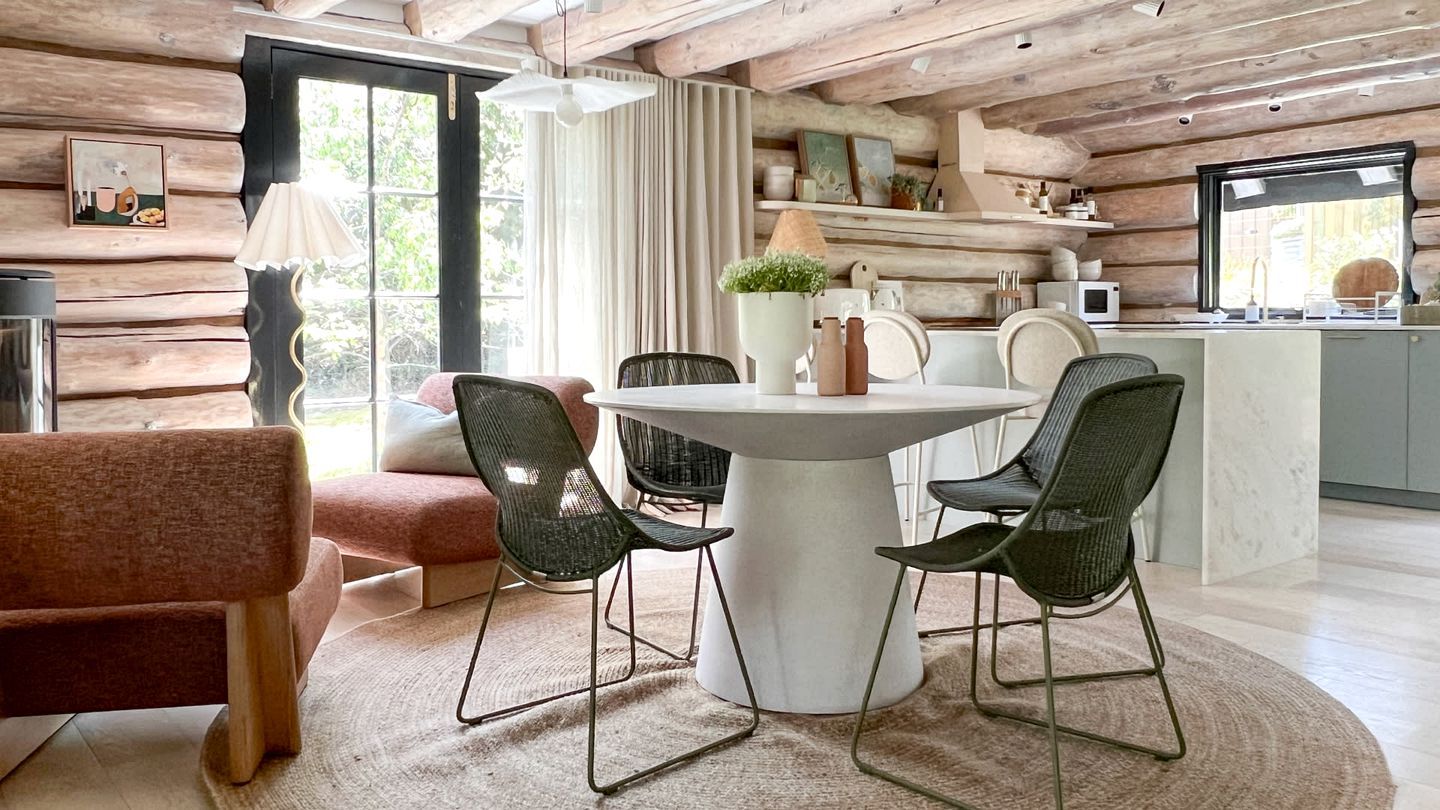 A cozy dining area with a round table, four chairs, and a central vase.