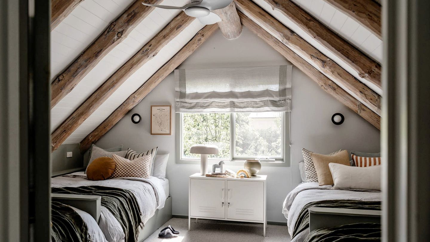 Ein Schlafzimmer mit zwei Betten, einem Fenster mit Blick, einem Deckenventilator und einem weißen Nachttisch.
