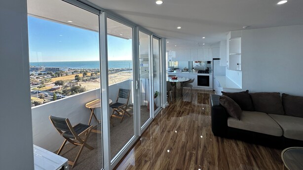 Ein modernes Apartment mit Balkon, Essbereich und Wohnzimmer.