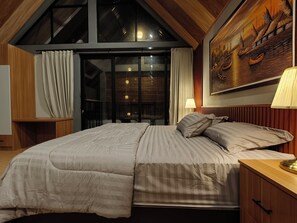 A bedroom with a large bed, wooden ceiling, and a painting of boats. - Relung Villas Pakem Kaliurang (Pakem)