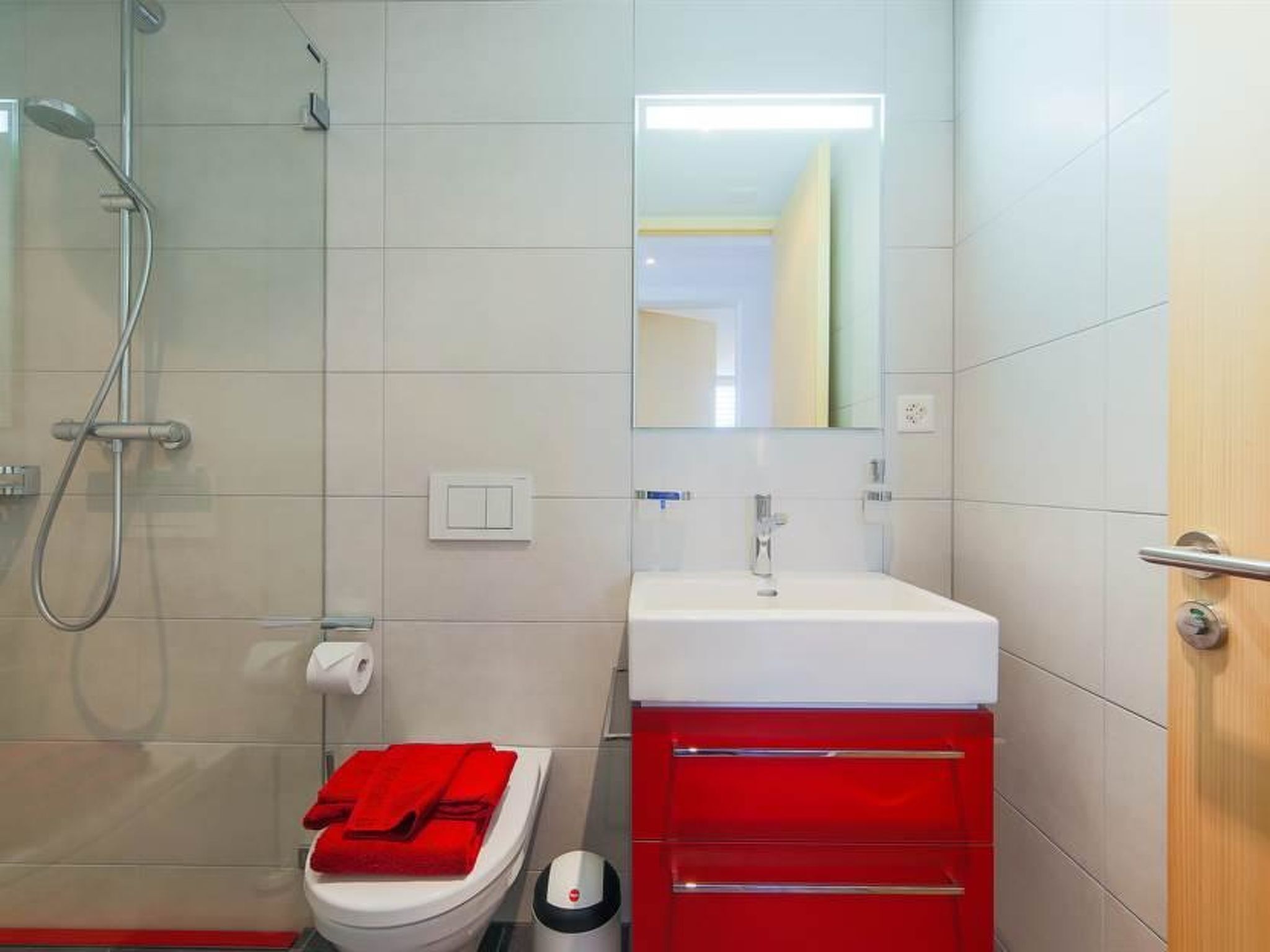 A modern bathroom with a shower, toilet, and sink.