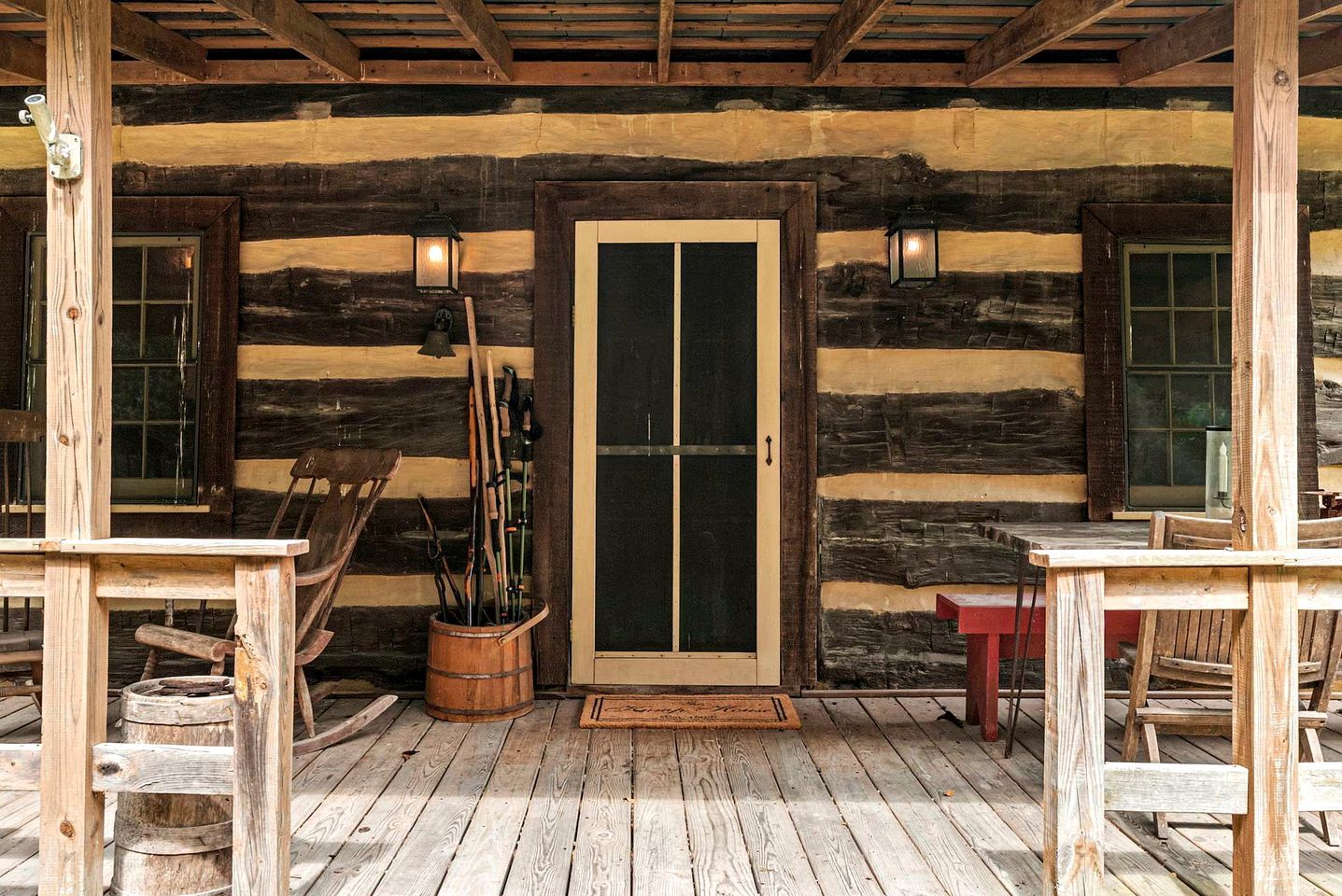 A rustic wooden cabin with a porch, a door with glass panels, and a wooden bench.