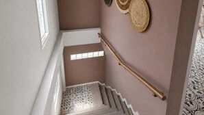 Un escalier avec une rampe en bois et des carreaux de sol à motifs.