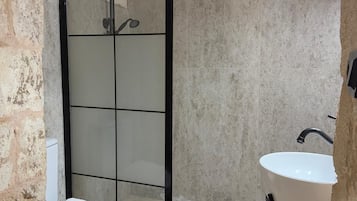 Une salle de bain avec une douche, des toilettes et un lavabo.