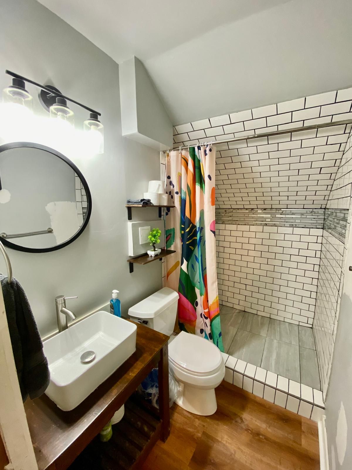 A bathroom with a white sink, toilet, and shower area.