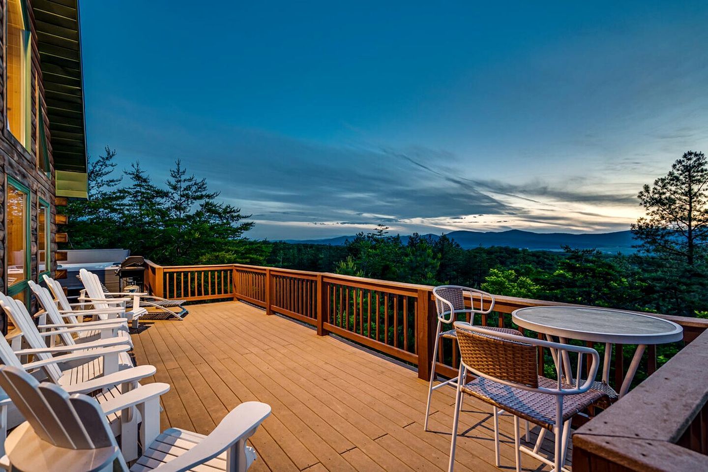 A wooden deck with outdoor seating and a view of a mountainous landscape.