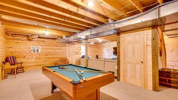 Un intérieur en bois avec une table de billard, un canapé et un panneau indiquant une vente.