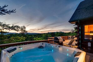 Uma banheira de hidromassagem em um deck com vista para a paisagem.