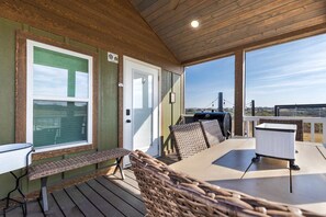 Eine Terrasse im Freien mit einem Tisch, Stühlen, einem Grill und Blick auf die Landschaft.