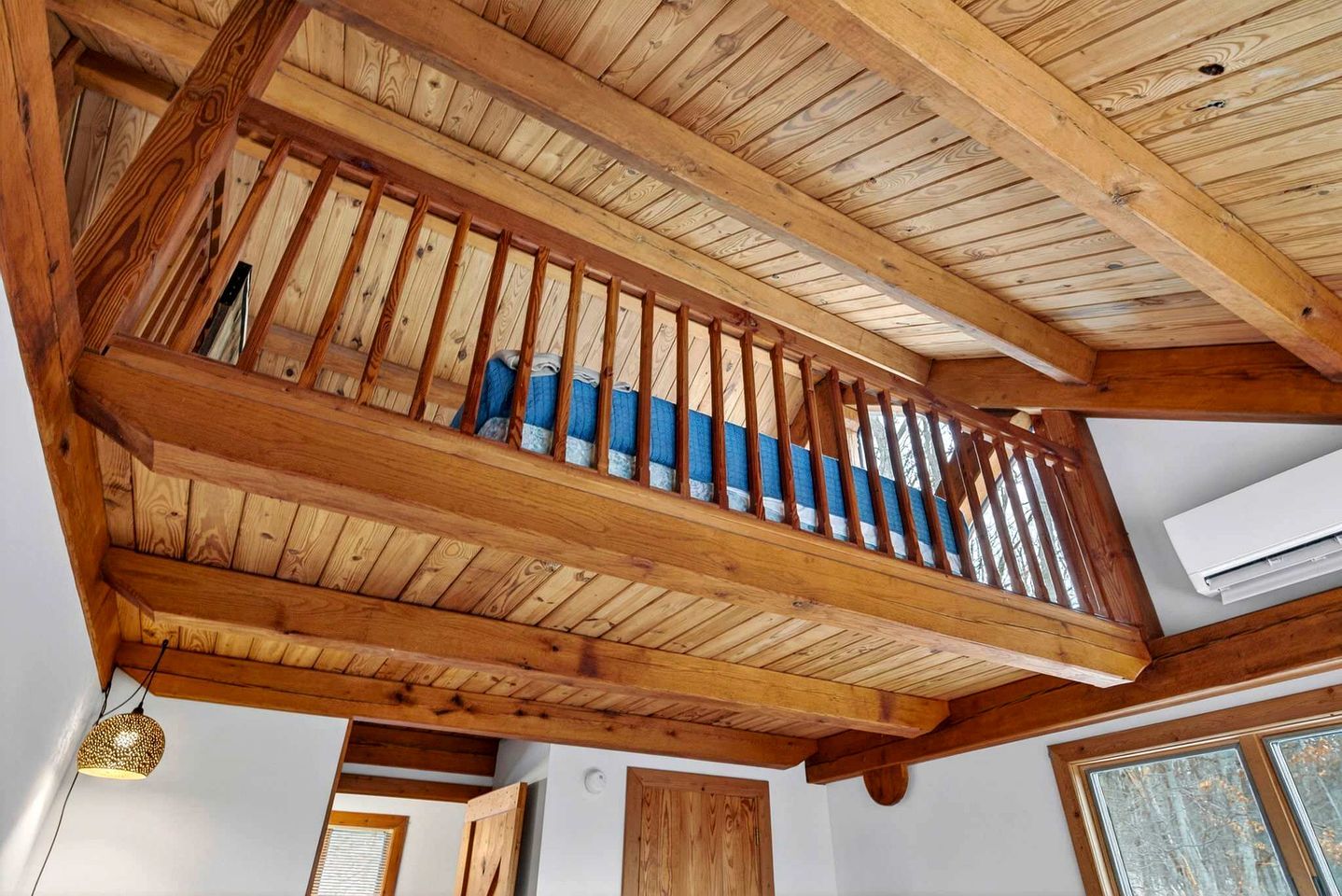 A wooden staircase with a handrail, leading to an upper level.