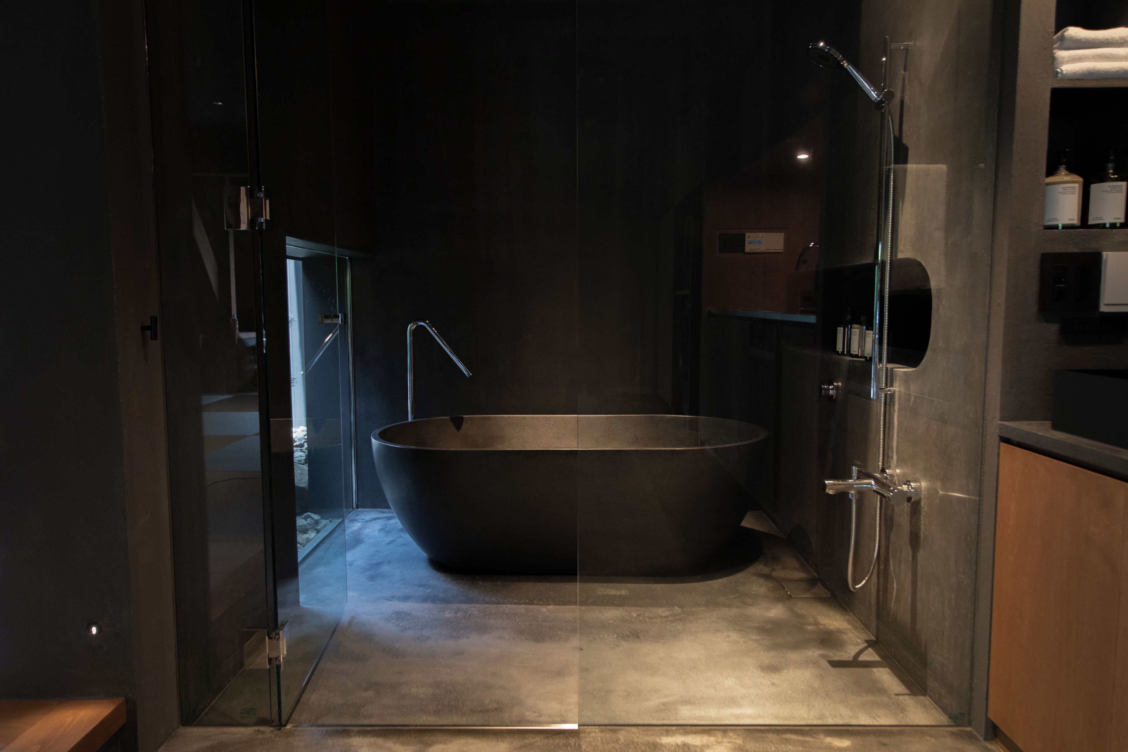 A modern bathroom with a freestanding bathtub, glass shower enclosure, and a visible towel rack.
