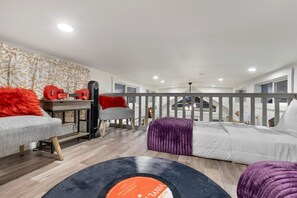 A modern bedroom with a bed, a desk, a chair, and a guitar. - Relaxing Tiny Home Retreat with Resort Amenities Near Fredericksburg, TX (Fredericksburg)