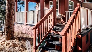 A wooden cabin with a porch, a staircase, and a welcome sign. - Quaint Tiny House in Woodland Park, Colorado near Garden of the Gods (Woodland Park)