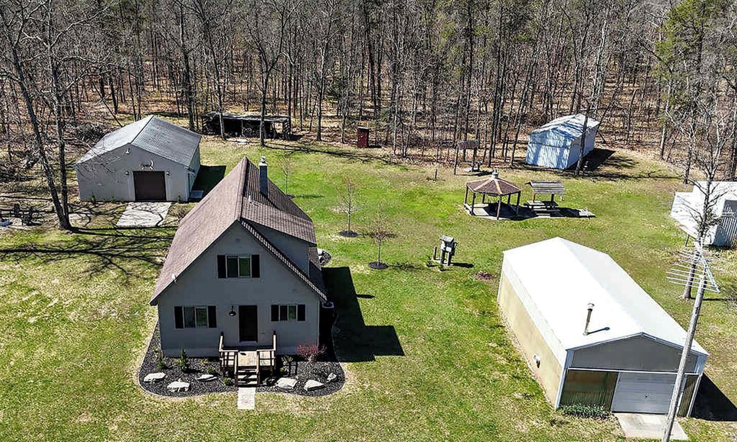 Un quartier résidentiel comprenant une maison principale, un garage, un abri de jardin et un petit pavillon.