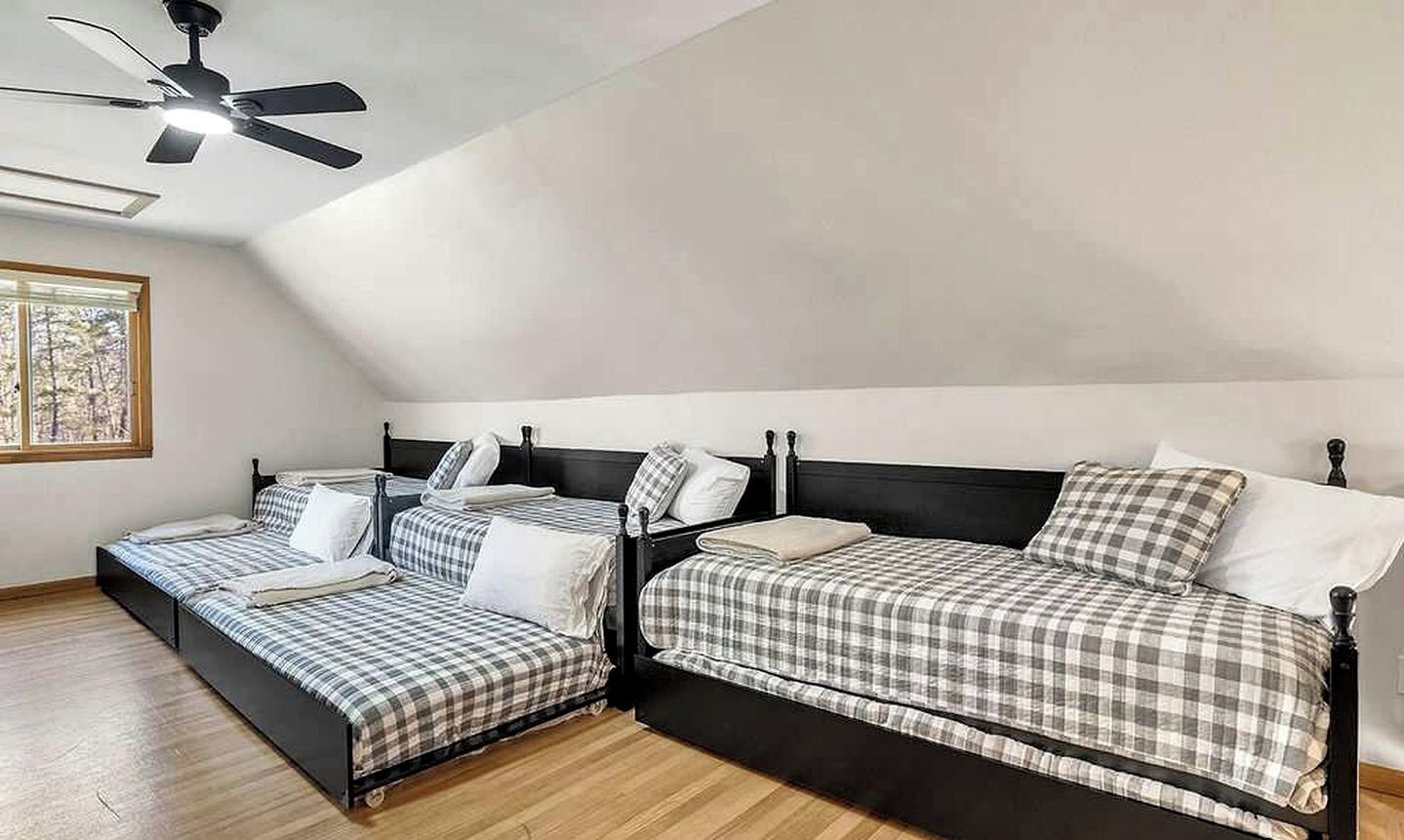 Ein Zimmer mit zwei Betten, einem Deckenventilator und einem Fenster mit Blick.