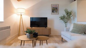 A living room with a TV, lamp, sofa, and a framed picture on the wall. - Stunning 3-bed Home in Newark by Renzo, Free Parking, Hotel Alternative (Newark-on-Trent)