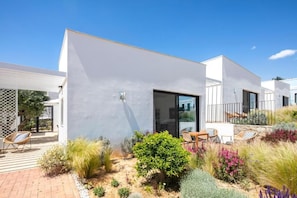 A modern house with a patio area, outdoor seating, and a variety of plants. - Paraiso Azul (Faro)