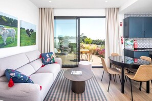 A modern living room with a sofa, coffee table, and dining area.