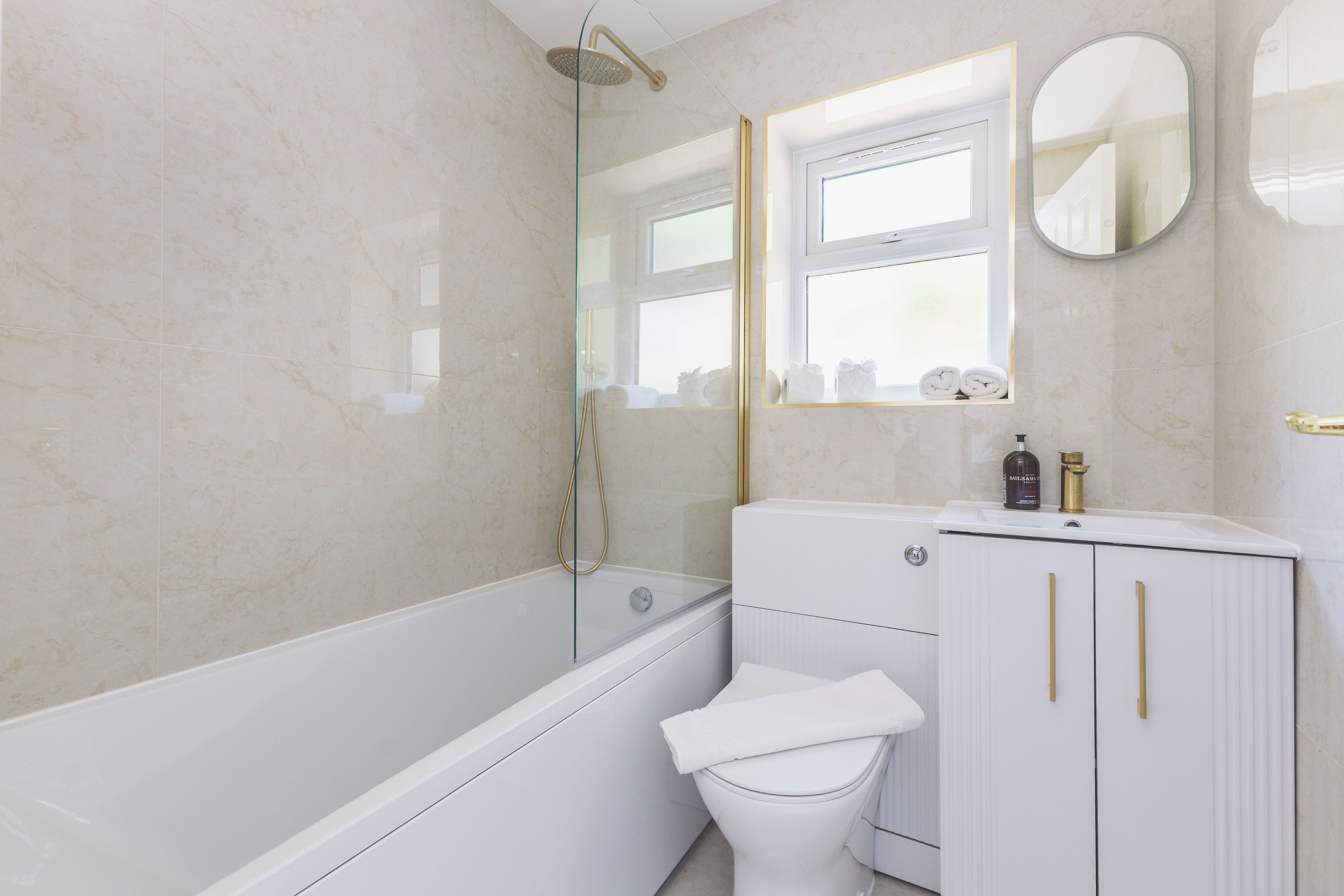 A modern bathroom with a bathtub, toilet, and vanity.