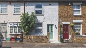 A row of terraced houses with white and red doors, a green door, and a small tree in front of one house. - Modern 2BDR 2BA Oasis near Richmond and Twickenham (Greater London)