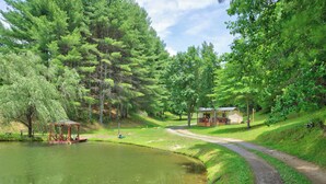 A tranquil park with a pond, a gazebo, and a small building with a porch. - Cozy lakeside cabin with peaceful views, a covered porch, fire pit, and private rural getaway. (Galax)