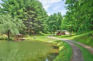A tranquil park with a pond, a gazebo, and a small building with a porch. - Cozy lakeside cabin with peaceful views, a covered porch, fire pit, and private rural getaway. (Galax)