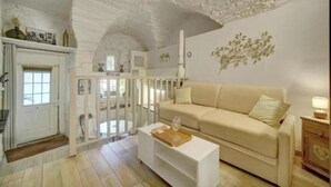 A living room with a high ceiling, a beige sofa, a white coffee table, and a white cabinet. - L'Eden - Unique and Charming - Suquet (Cannes)